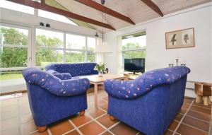 凡岛林威法诺十号度假屋的客厅配有2把蓝色椅子和桌子