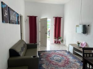 珍南海滩Safiyya Homestay的带沙发和红色窗帘的客厅