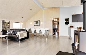 博恩瑟Gorgeous Home In Bogense With Indoor Swimming Pool的客厅配有黑色沙发和白色椅子