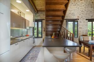 SívaVilla Lambraki的厨房配有白色橱柜和木制天花板