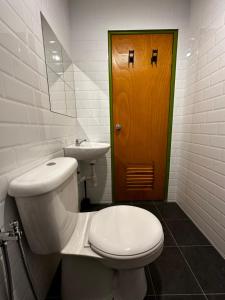 淡文Olive Bedz Hotel的一间带卫生间、水槽和门的浴室
