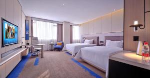 深圳深圳北站希尔顿欢朋酒店的酒店客房设有两张床和电视。