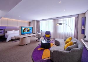 深圳深圳北站希尔顿欢朋酒店的酒店客房配有床、沙发和电视。