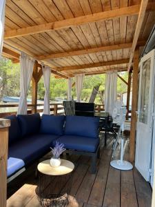 耶泽拉DM mobile home的客厅设有一张位于木甲板上的蓝色沙发