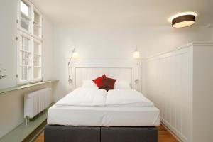 海德堡Palmbräu Altstadt Appartments的卧室配有白色的床和红色枕头