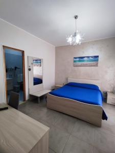 切萨雷奥港阿尔伯格普利玛维拉旅馆的一间带蓝色床的卧室和一间浴室