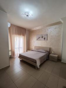 切萨雷奥港阿尔伯格普利玛维拉旅馆的一间卧室设有一张大床和一个窗户。