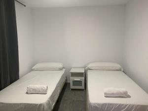圣费尔南多APTO BAHIA SUR RESERVA DE CONFIANZA的两张睡床彼此相邻,位于一个房间里