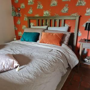LicquesLa Longère d'Ecottes的橙色墙壁间的一张床位