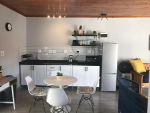 比勒陀利亚Blue Lotus Guest House Pta East-No Loadshedding的厨房配有桌椅和冰箱。