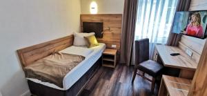 索尔陶索尔陶尔海德花园酒店的小房间设有一张床和一张书桌