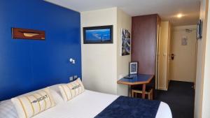 欧赖勒马林酒店的酒店客房设有一张大床和蓝色的墙壁。