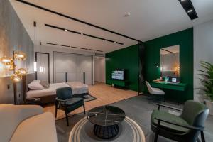 阿克套Dostyk Business Hotel的一间卧室设有绿色的墙壁、一张床和一张桌子