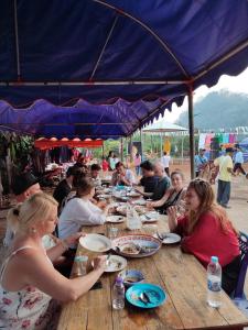 拜县Topp paiway hostel的一群坐在餐桌上吃食物的人