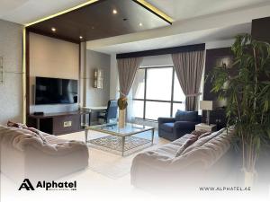 迪拜Alphatel Beach Hostel JBR的客厅配有两张沙发和一台电视机