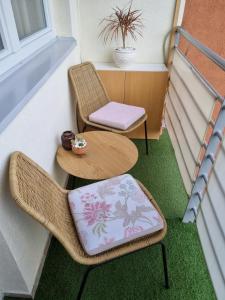 克拉列沃Apartman Centar的阳台配有两把椅子、一张桌子和一张桌子以及椅子。