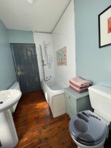 基尔马勒克Mai's Cottage Suite - Charming Holiday Rental的浴室配有卫生间、盥洗盆和浴缸。