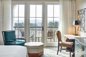 胡佛伯明翰玫瑰桥万丽高尔夫度假酒店的酒店客房,配有一张床、一张桌子和椅子