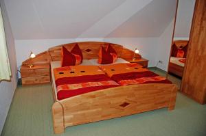 奥斯赛拜-塞林Ferienhaus unterm Reetdach的一间卧室配有一张带红色枕头的大型木制床。