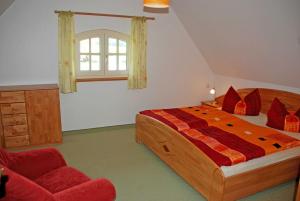 奥斯赛拜-塞林Ferienhaus unterm Reetdach的一间卧室配有一张大床和一张红色椅子