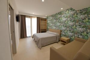 GonnosfanàdigaL'OLEANDRO Room's - Suite & Spa da Giuseppe的一间卧室设有一张床和花卉墙
