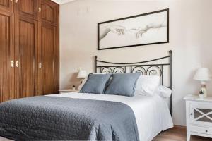 雷阿尔城Unifamiliar Europa的一间卧室配有黑色和白色的床以及蓝色枕头