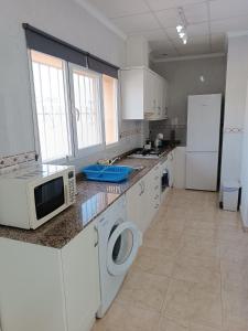 卡尔佩Villa Noemi, con piscina privada的厨房配有白色橱柜、微波炉和冰箱。