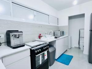 巴特亚姆New! Your home in Israel Luxury Suite的厨房配有白色橱柜和黑色用具