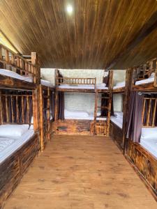 卡索尔Parvatis Lap Luxury Hostel & Camps的客房设有三张双层床和木制天花板。