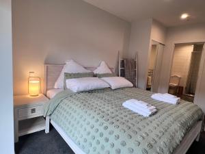 奥克兰3 bedroom apartment in Newmarket的一间卧室配有一张床,上面有两条毛巾