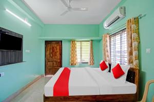 布巴内什瓦尔Das Inn的一间卧室配有一张带红色枕头的大床