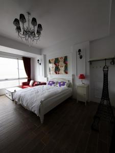 台东伊亚咖啡民宿的卧室配有一张白色大床和吊灯。