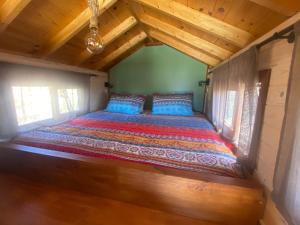 吉亚德伊索拉Mini Casa Finca Arcoiris Tenerife的小屋的一张床位,设有木制天花板
