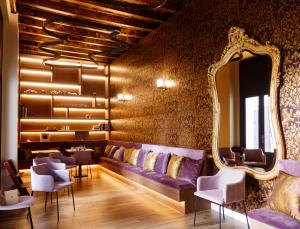 科尔多瓦Casa del Cardenal的一个带紫色沙发和镜子的沙龙