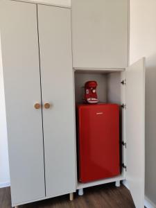 旧瓦马Daro tiny house的白色橱柜中的红色冰箱