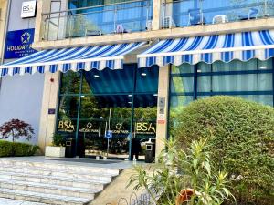 金沙BSA Holiday Park Hotel - All Inclusive的建筑前方有蓝色遮阳篷