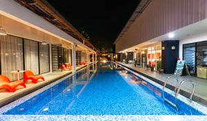 珍南海滩兰卡威别墅酒店的一座大型游泳池,里面设有橙色椅子