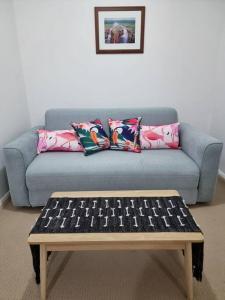 珀斯Little Monica Apartment- Spacious, Affordable & Central的蓝色沙发、枕头和咖啡桌