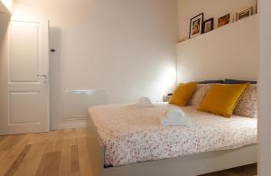 普拉托CALIMARA18 25" from Florence AC SmartTV的白色卧室配有黄色枕头的床