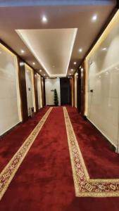 利雅德الماسم للأجنحة المخدومة- الملك فهد的一条铺有红地毯的走廊和一条长长的带圣诞树的走廊