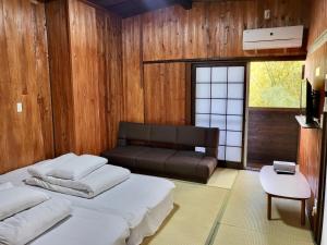 由布市旅館 竹屋 Takeya的一间卧室配有一张床和一张沙发