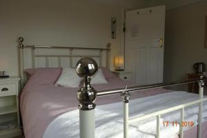 UplymeWestley B&B的一间卧室配有一张粉红色床单