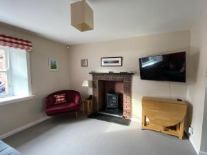 北贝里克Charming Cottage in North Berwick with Sea Views的客厅设有壁炉和平面电视。
