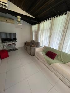 伊塔佩马Linda Casa frente mar, pé na areia, Itapema SC, Ar, Wi-fi, Smart Tv的带沙发和电视的客厅