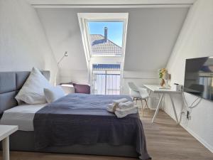 比勒费尔德Stadt-Appartement Work & Travel的一间卧室配有一张床、一张书桌和一个窗户。