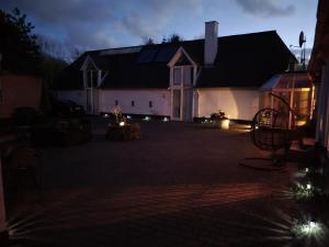 艾特韦Trandafir Guesthouse的庭院里晚上有灯的房子