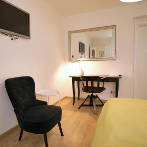 格拉茨吕克特别墅酒店的客房设有书桌、椅子和镜子