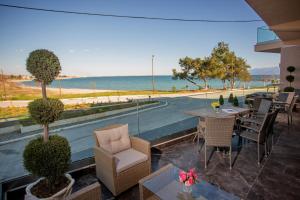 内亚卡瓦里Kavala Resort & Spa的一个带桌椅的庭院和大海