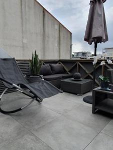 腓特烈斯塔Modern loftsleilighet的天井上的一把空椅子和一把遮阳伞