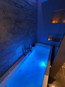 腓特烈斯塔Modern loftsleilighet的浴室配有蓝色灯光的大浴缸